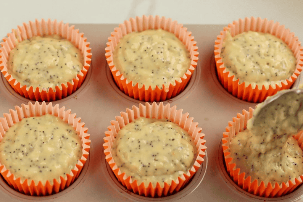 filling poppy seed muffin tins