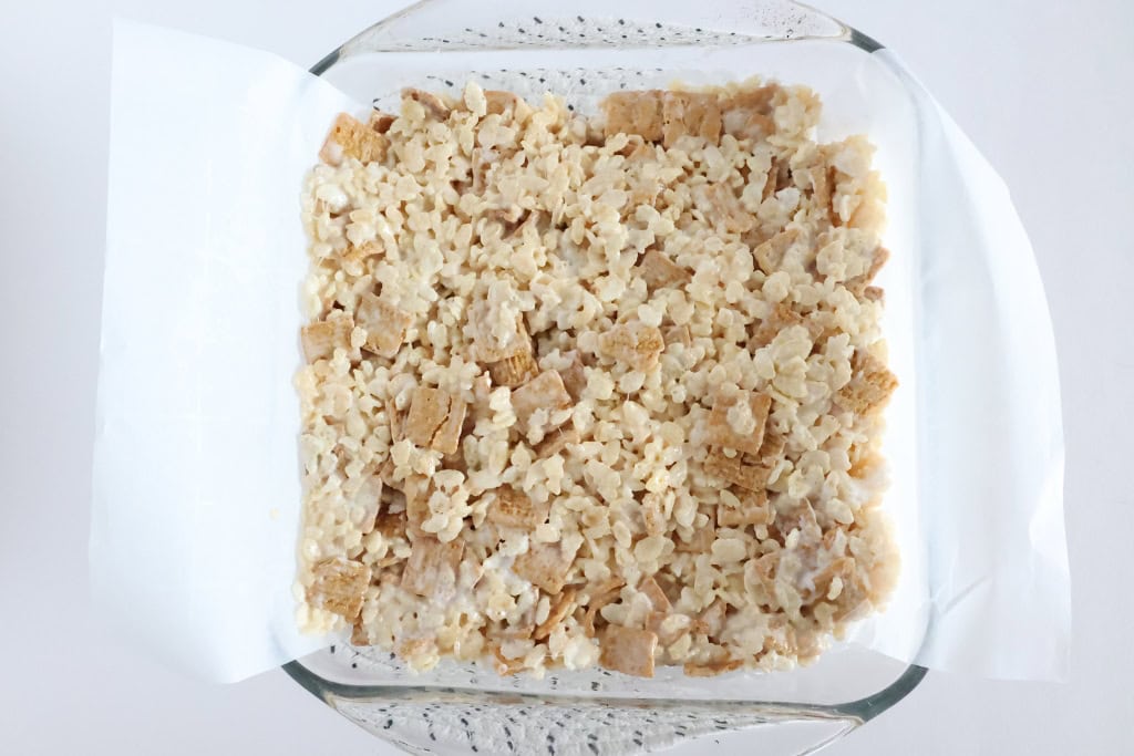 Mixed ingredients of S'mores Rice Krispies pressed into baking dish