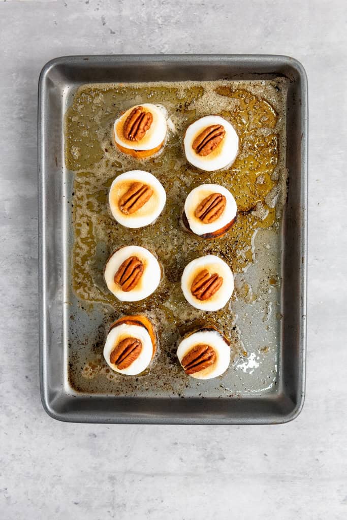 baked sweet potatoes topped with marshmallow and pecan