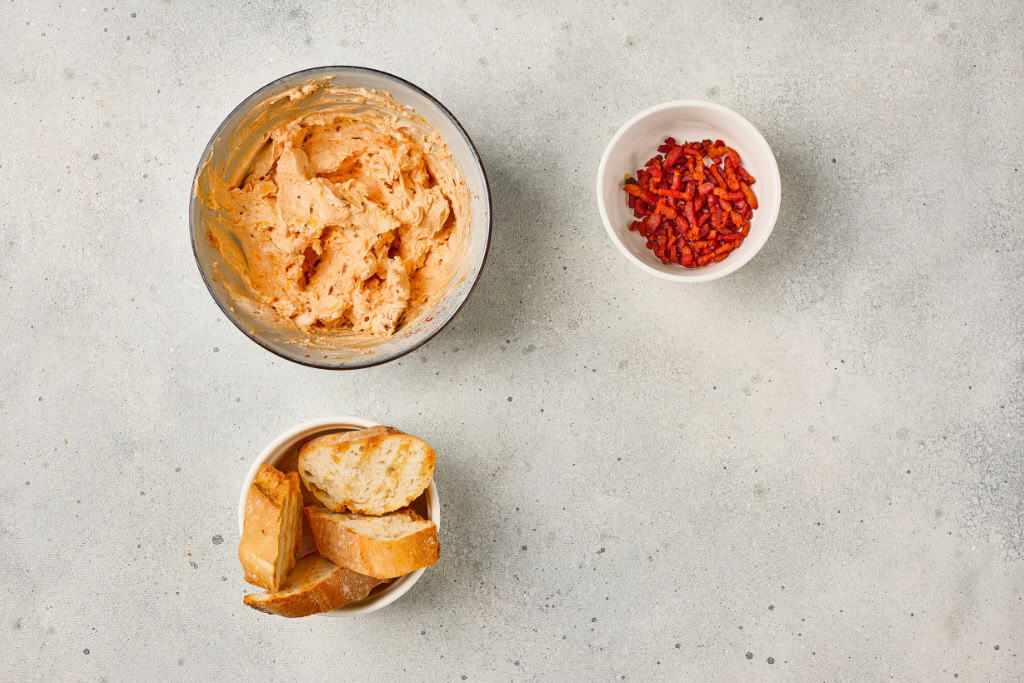 ingredients for Maple Bacon Cheese Dip mixed together in a bowl, sliced bread