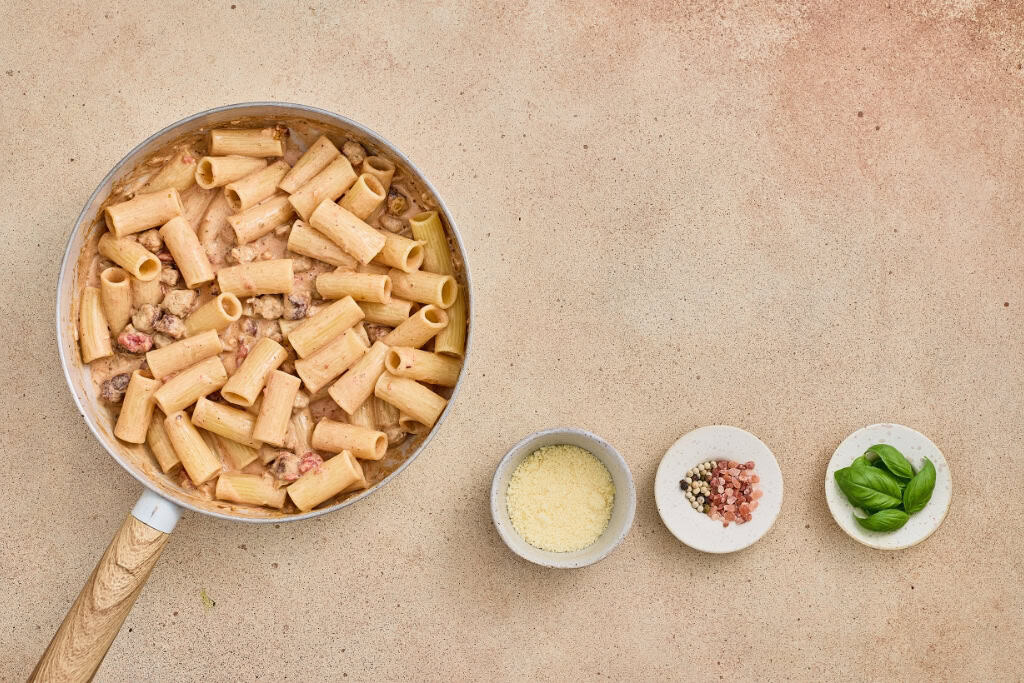 mixing in the rigatoni to the sauce