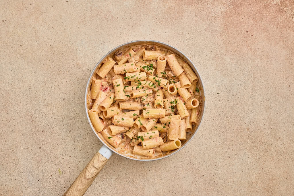 garnishing with cheese and chopped basil