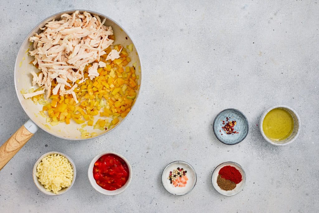 adding shredded chicken to the pan